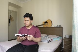 Ein junger Mann beim Schriftstudium