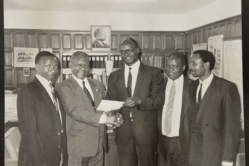 group of men standing in an office