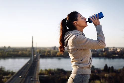 woman drinking water while exercising