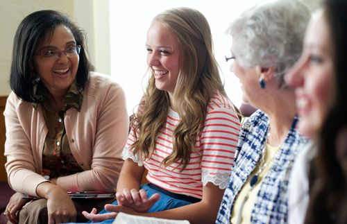 women sitting and smiling together in Relief Society