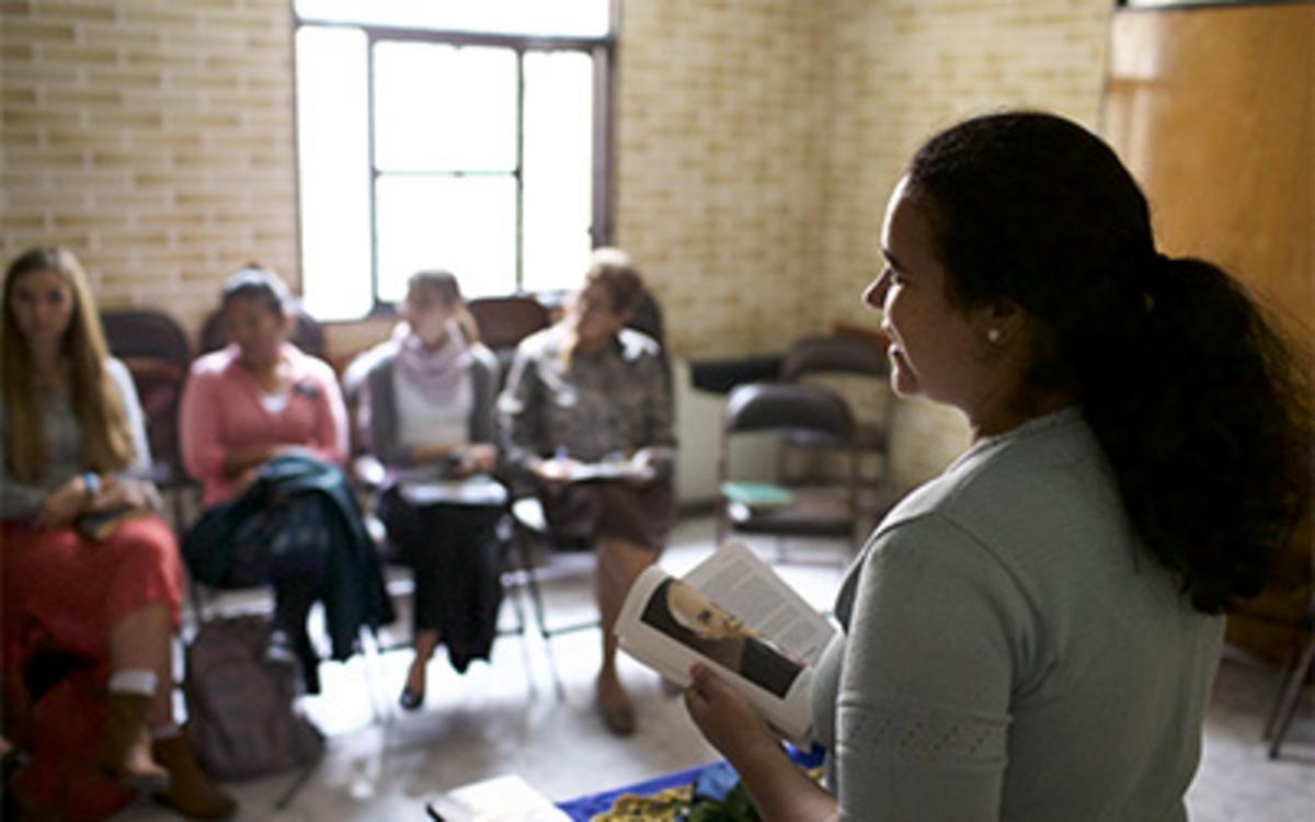 Jovens em classe sendo ensinados por um professor.