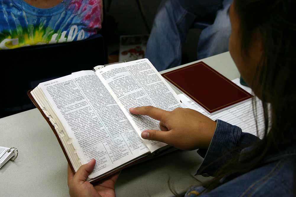 Una jovencita lee las Escrituras